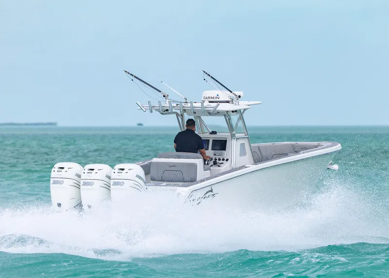 Slide: The Image of 2021 Blackwater 36 Sport boat speeding on ocean with four engines, clear sky background. - 2