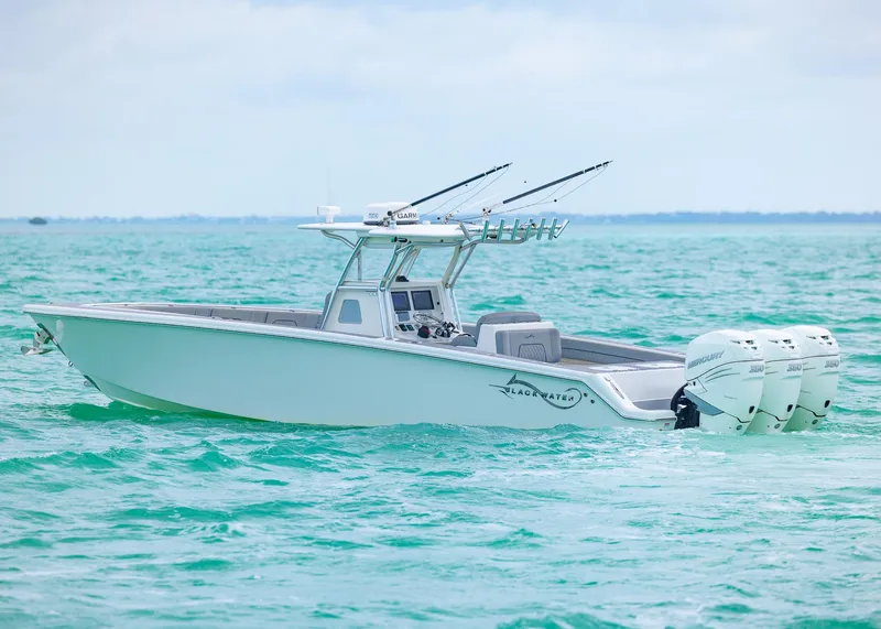 Slide: The Image of 2021 Blackwater 36 Sport boat on turquoise water, featuring triple outboard engines. - 3