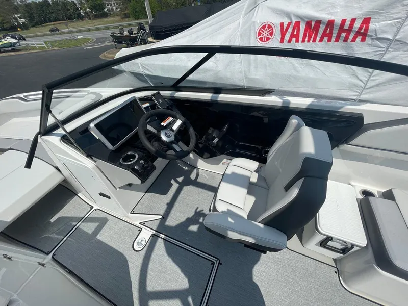 Slide: The Image of 2025 Yamaha AR250 boat interior with steering wheel and seating, under a Yamaha-branded cover. - 10