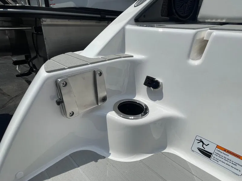 Slide: The Image of 2025 Yamaha Boats AR250, white interior detail with cup holder and safety warning. - 7