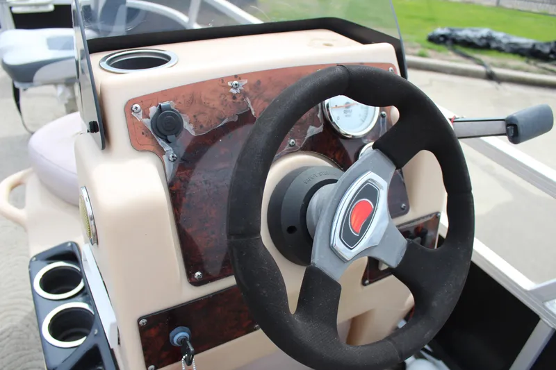 Slide: The Image of 2014 Sun Tracker Bass Buggy 18 DLX steering console with cup holders and gauges. - 17