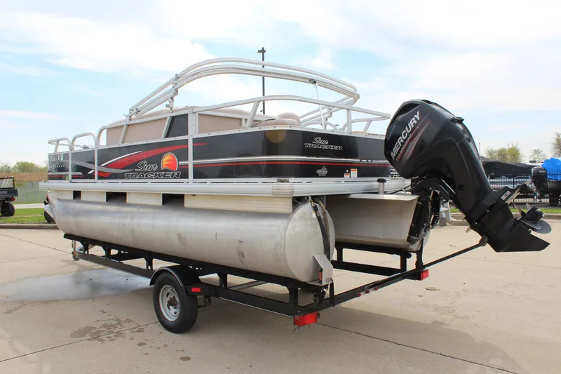 Slide: The Image of 2014 Sun Tracker Bass Buggy 18 DLX pontoon boat on trailer, featuring Mercury outboard motor. - 5