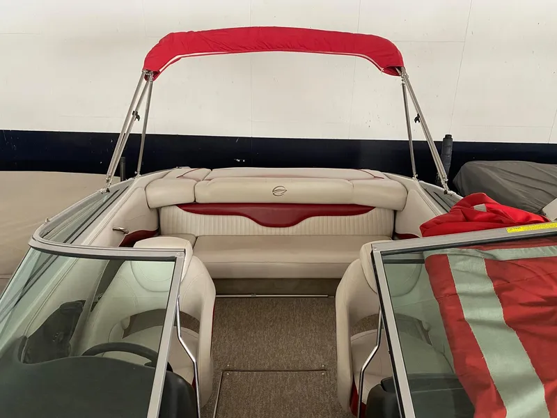 Slide: The Image of 2012 Crownline 21 SS boat interior with red canopy and beige seating. - 16