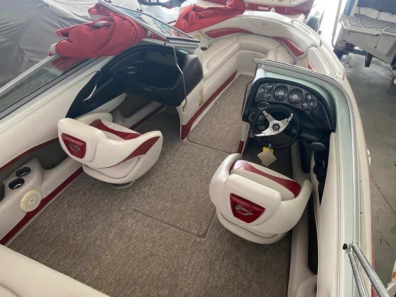 Slide: The Image of 2012 Crownline 21 SS boat interior with white and red seating, dashboard, and steering wheel. - 7