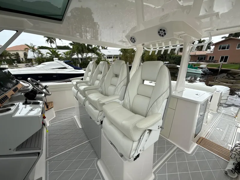Slide: The Image of 2021 Regal 38 SAV boat interior with luxurious white seating and modern dashboard. - 19