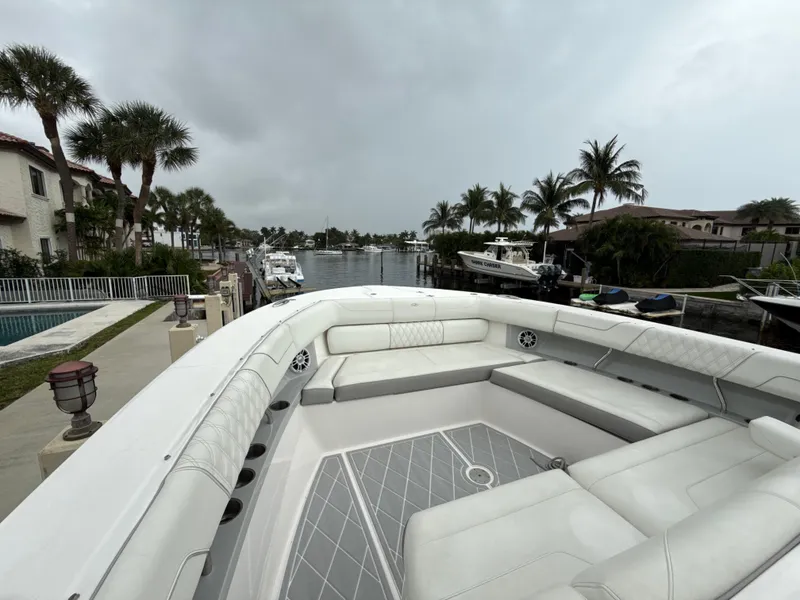 Slide: The Image of 2021 Regal 38 SAV boat with spacious seating, docked near palm trees and waterfront homes. - 21