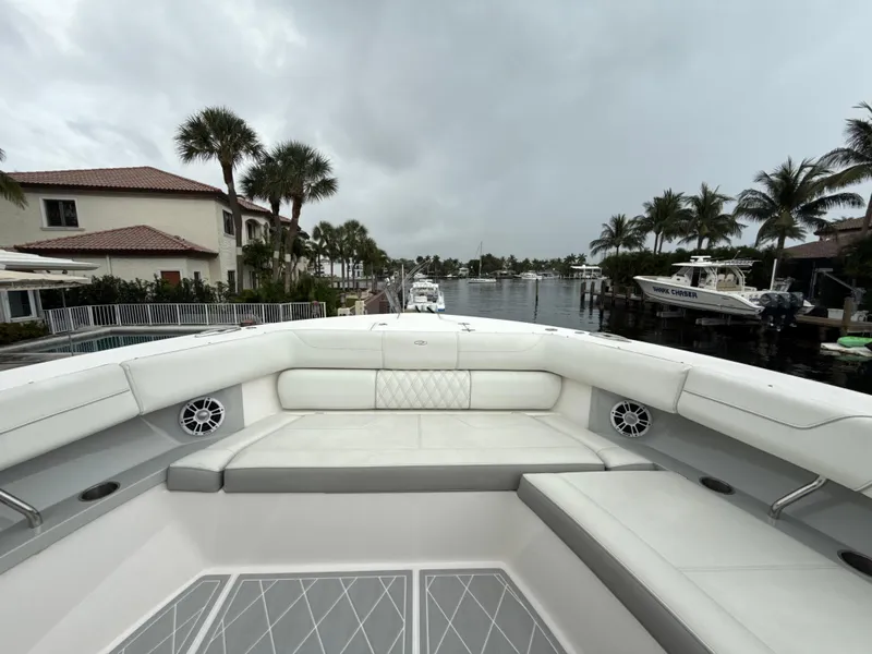 Slide: The Image of 2021 Regal 38 SAV boat interior with luxurious seating, docked near waterfront homes. - 22