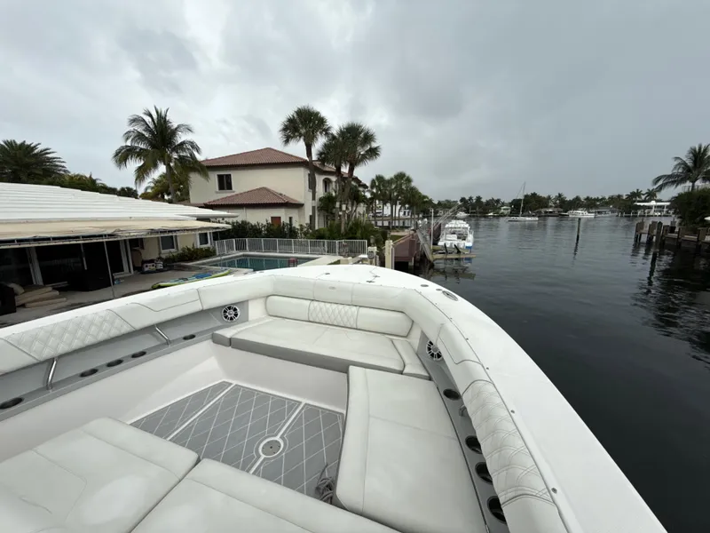 Slide: The Image of 2021 Regal 38 SAV boat docked by waterfront homes with palm trees. - 23