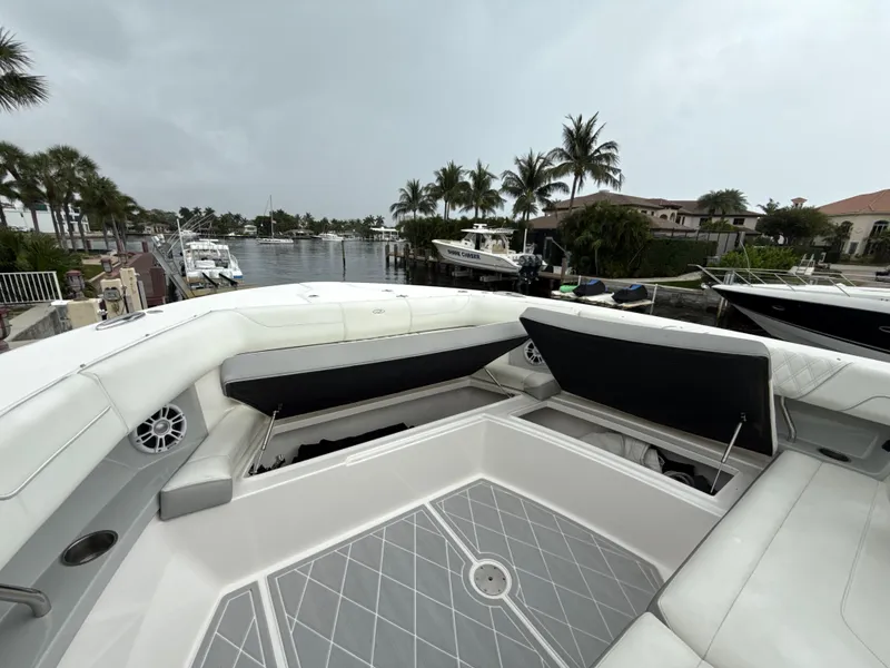 Slide: The Image of 2021 Regal 38 SAV boat interior with open storage, docked near palm trees and waterfront homes. - 24
