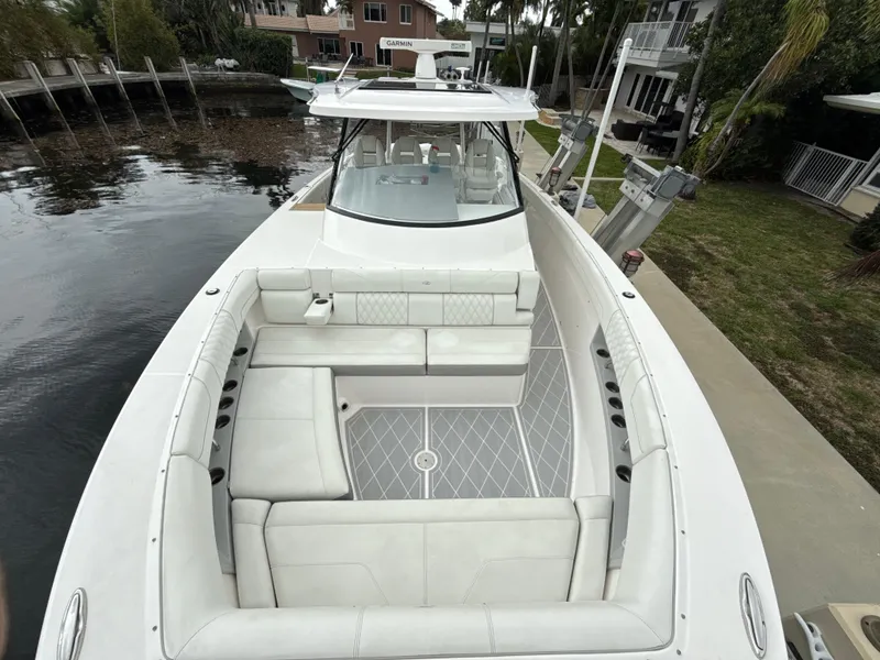 Slide: The Image of 2021 Regal 38 SAV boat with spacious seating, docked by a waterfront property. - 26