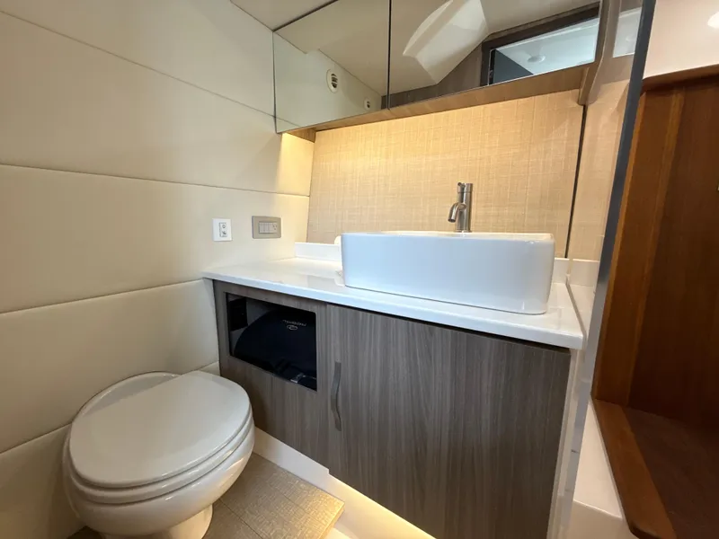 Slide: The Image of 2021 Regal 38 SAV bathroom with modern sink, toilet, and wood cabinetry. - 29