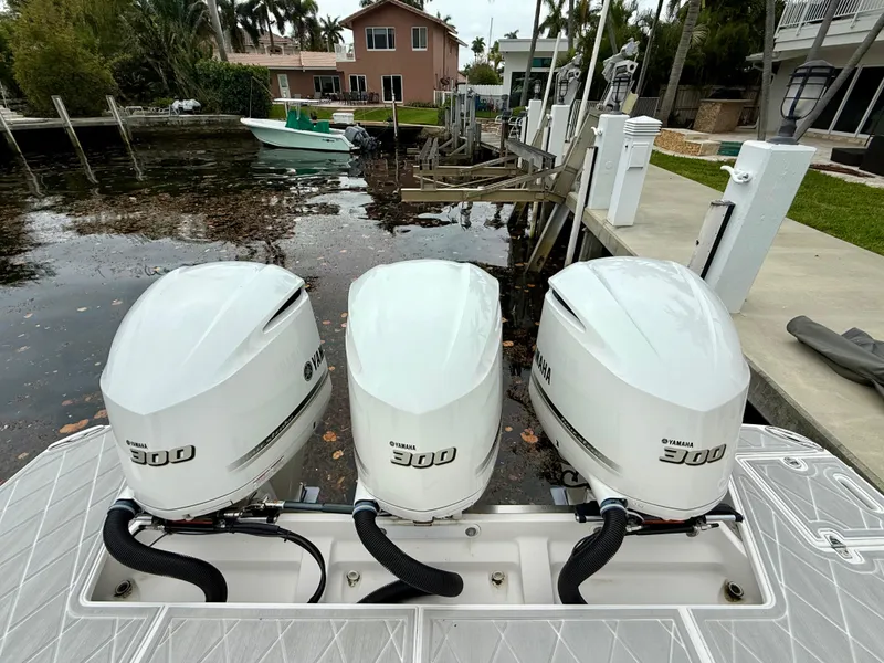 Slide: The Image of Triple Yamaha 300 outboard engines on a 2021 Regal 38 SAV boat docked by a canal. - 3