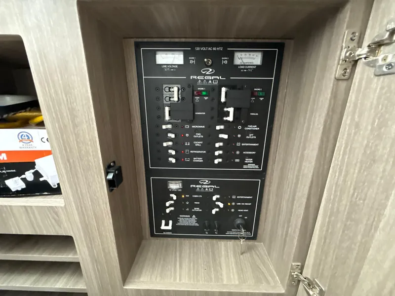 Slide: The Image of Electrical control panel on a 2021 Regal 38 SAV boat, featuring various switches and meters. - 31