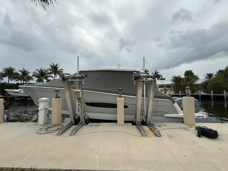 Slide: The Image of 2021 Regal 38 SAV boat docked with overcast sky and palm trees in the background. - 34