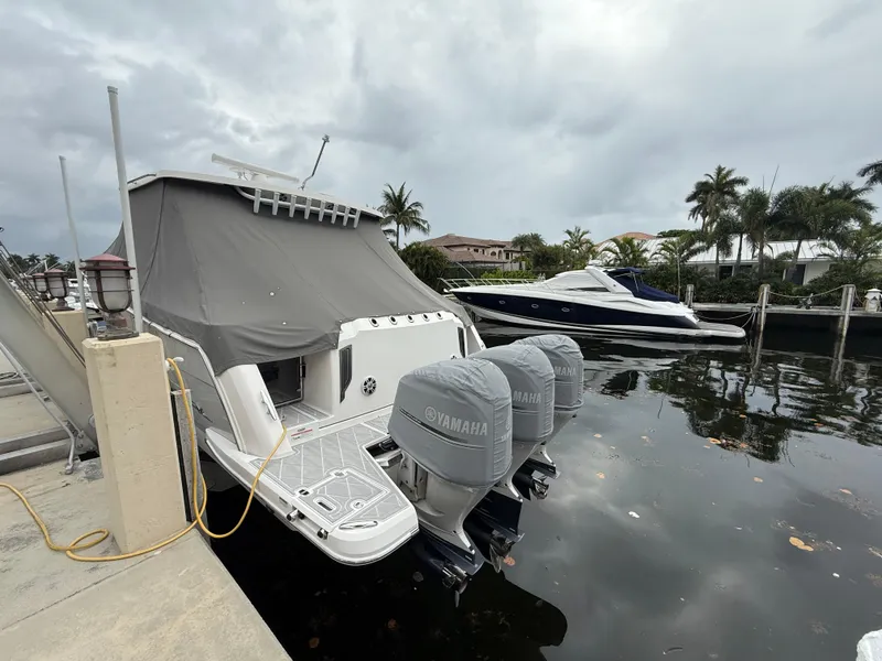 Slide: The Image of 2021 Regal 38 SAV boat docked with Yamaha engines, covered, in a marina setting. - 35