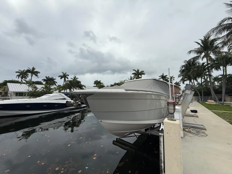 Slide: The Image of 2021 Regal 38 SAV boat docked near palm trees under cloudy skies. - 36