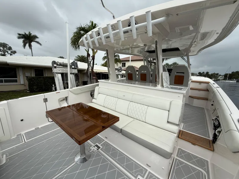 Slide: The Image of 2021 Regal 38 SAV boat with elegant seating and wooden table on deck. - 5