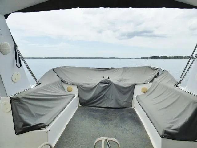 Slide: The Image of Interior view of a 1998 Fantasy 17x85 boat with covered seating and lake view. - 13