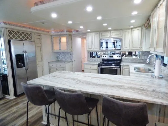 Slide: The Image of Luxurious kitchen in a 1998 Fantasy 17x85 houseboat with modern appliances and marble countertops. - 4