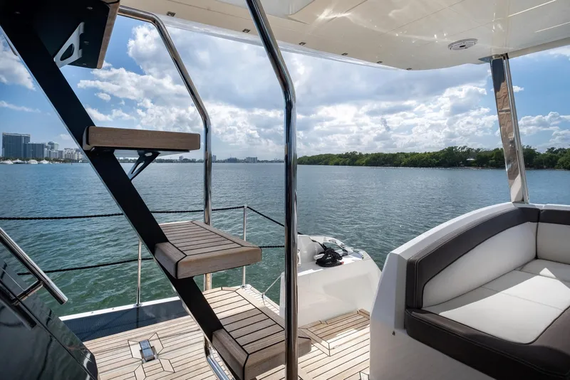 Slide: The Image of Luxurious Galeon 640 Fly yacht deck with stairs, overlooking serene water and skyline. - 15