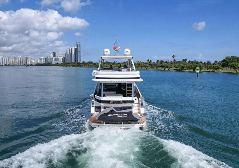 Slide: The Image of Galeon 640 Fly yacht cruising in scenic waters, city skyline in background, 2020 model. - 8
