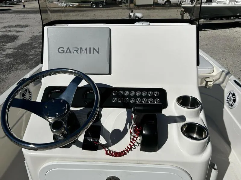 Slide: The Image of 2024 Skeeter SX230 boat console with Garmin navigation, steering wheel, and controls. - 13