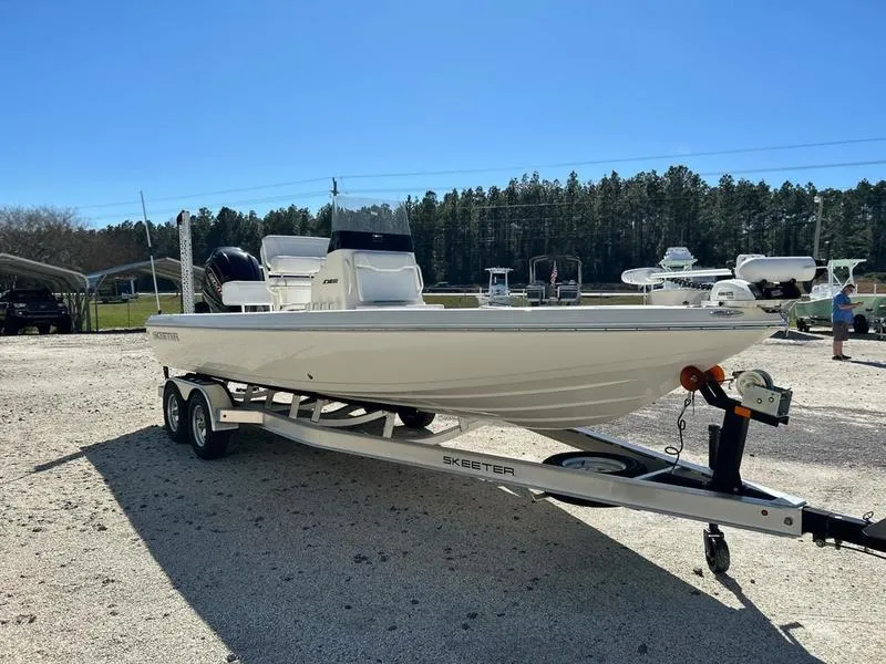 Slide: The Image of 2024 Skeeter SX230 boat on trailer, parked outdoors, clear sky background. - 3