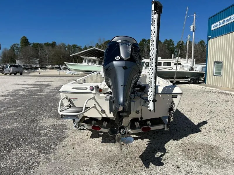 Slide: The Image of 2024 Skeeter SX230 boat with outboard motor in a sunny marina. - 6