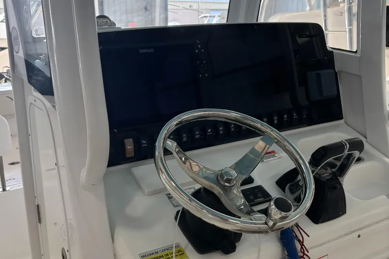 Slide: The Image of 2018 Sea Hunt Gamefish 25 boat dashboard with steering wheel and controls. - 3