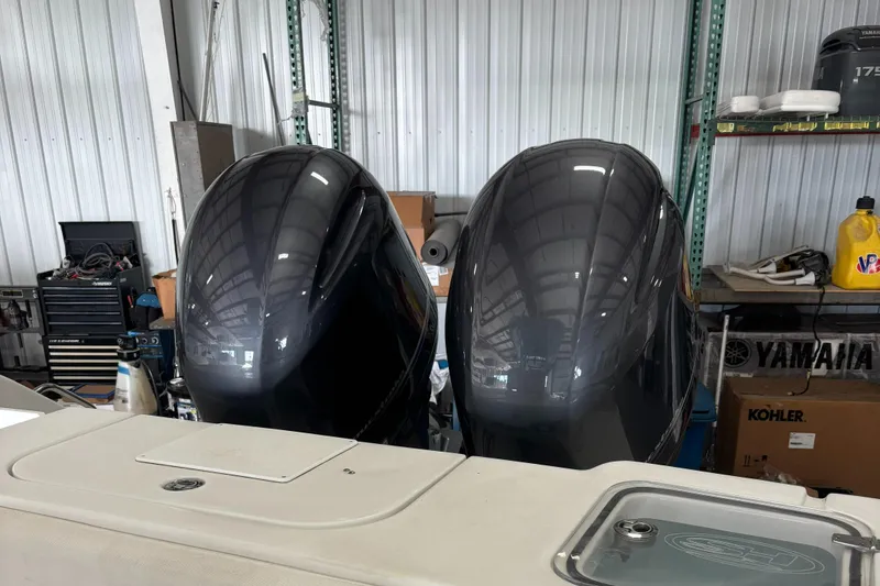 Slide: The Image of Twin outboard engines on a 2018 Sea Hunt Gamefish 25 in a garage setting. - 4