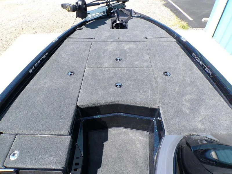 Slide: The Image of 2024 Skeeter ZX150 boat deck with carpeted surface and storage compartments. - 17