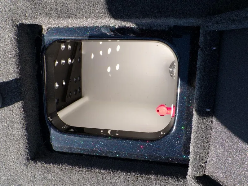 Slide: The Image of 2024 Skeeter ZX150 storage compartment with black trim and carpeted edges. - 32