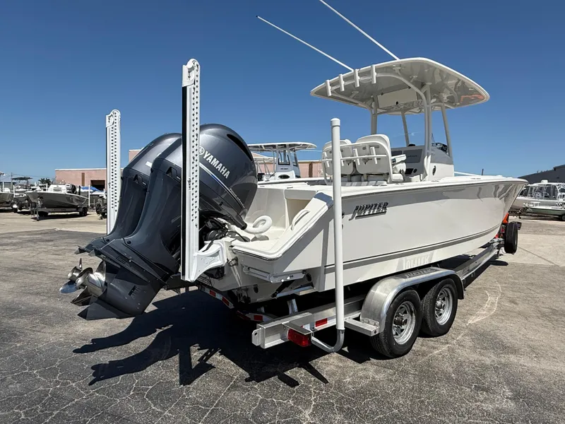 Slide: The Image of 2016 Jupiter 26 boat on trailer under clear blue sky. - 1
