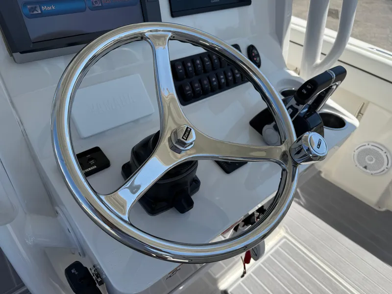 Slide: The Image of Steering wheel of a 2016 Jupiter 26 boat, featuring modern controls and dashboard. - 17
