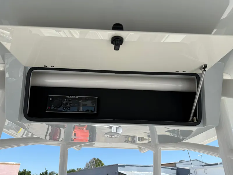 Slide: The Image of Overhead storage compartment in a 2016 Jupiter 26 boat with a radio device. - 19