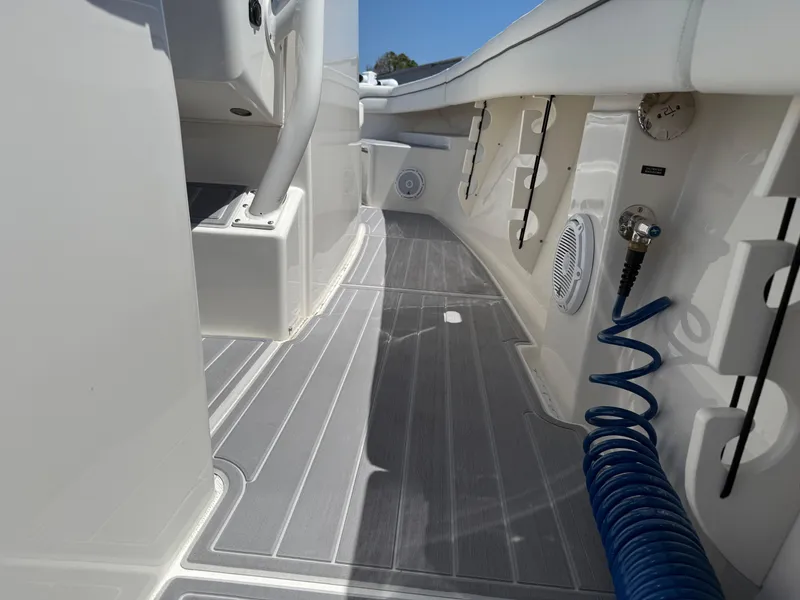 Slide: The Image of 2016 Jupiter 26 boat deck with gray flooring and blue coiled hose. - 21