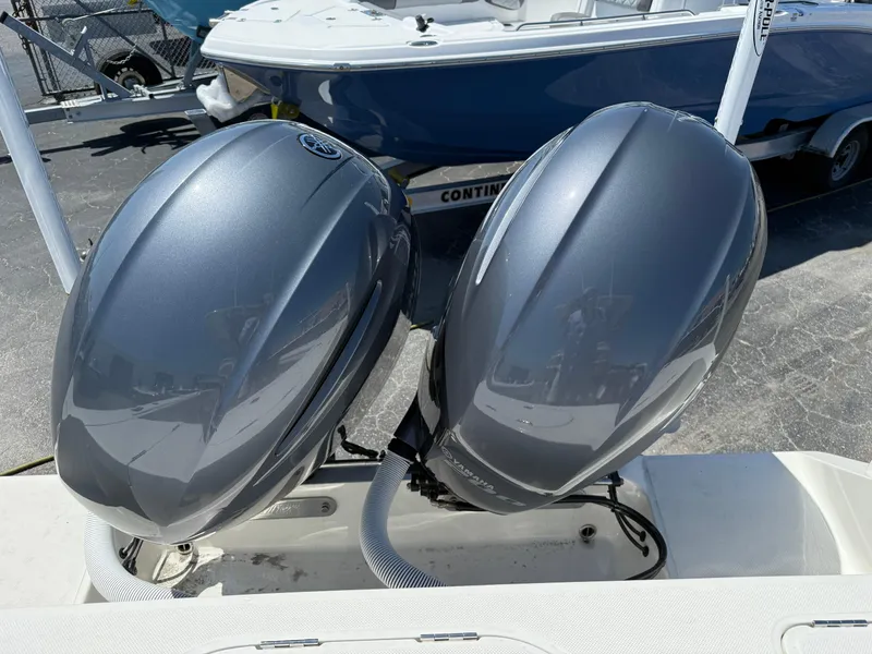 Slide: The Image of Twin outboard motors on a 2016 Jupiter 26 boat, parked at a marina. - 22