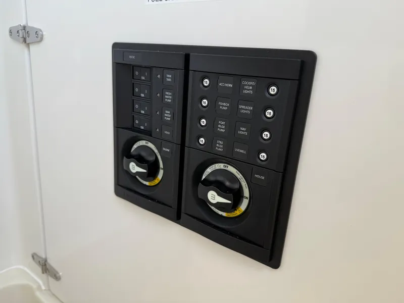 Slide: The Image of Control panel on a 2016 Jupiter 26 boat, featuring switches and dials. - 26