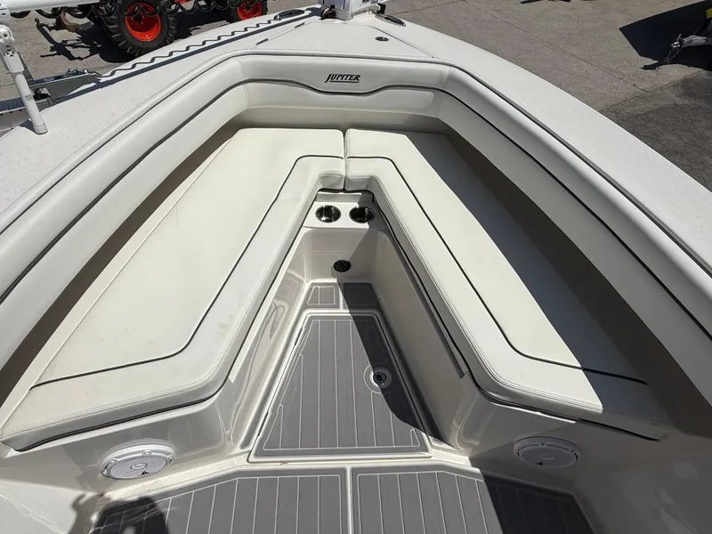 Slide: The Image of Bow seating area of a 2016 Jupiter 26 boat with white cushions and gray flooring. - 28