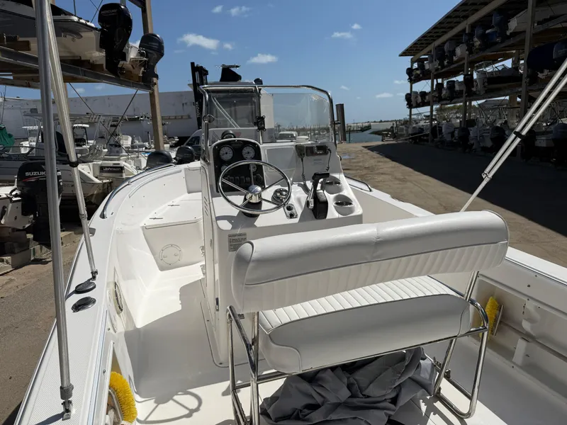 Slide: The Image of 2007 Sea Hunt 202 TRITON boat interior with steering console, docked under clear skies. - 7
