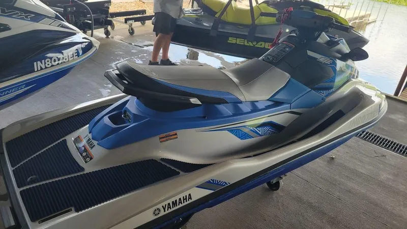 Slide: The Image of 2020 Yamaha WaveRunner EX Deluxe jet ski in blue and white, parked indoors. - 5