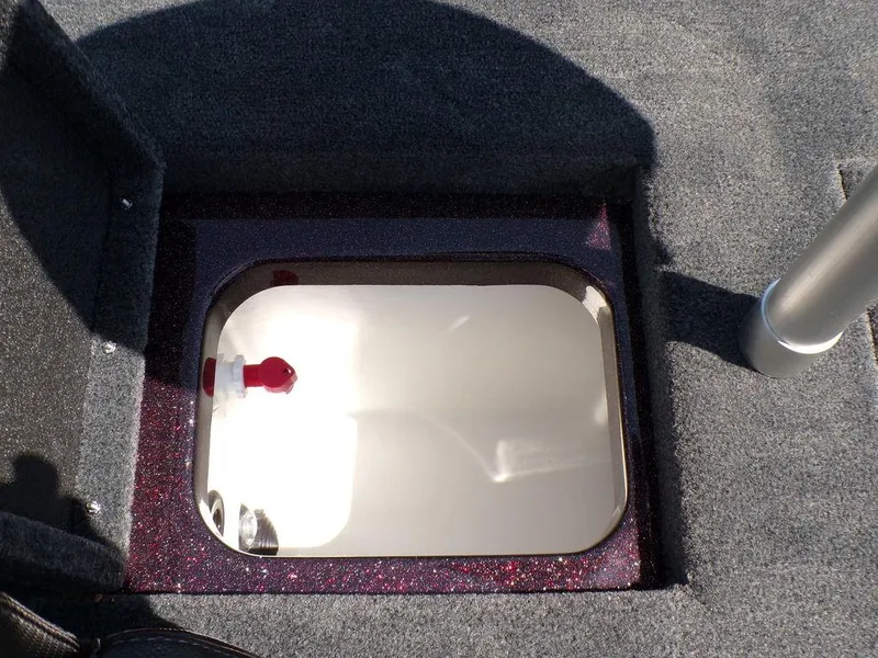 Slide: The Image of 2024 Skeeter ZX150 boat storage compartment with carpeted interior and latch. - 2