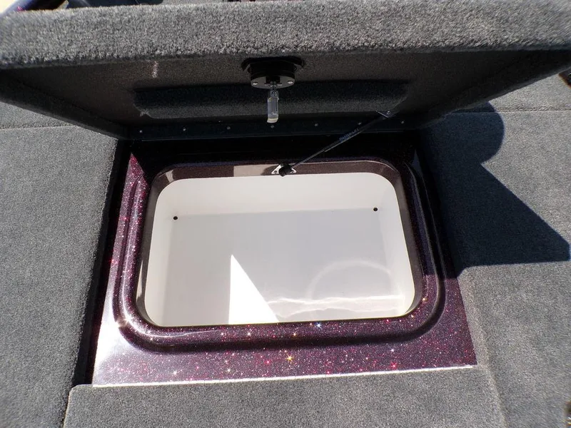 Slide: The Image of 2024 Skeeter ZX150 boat storage compartment with open lid, showing interior space. - 9