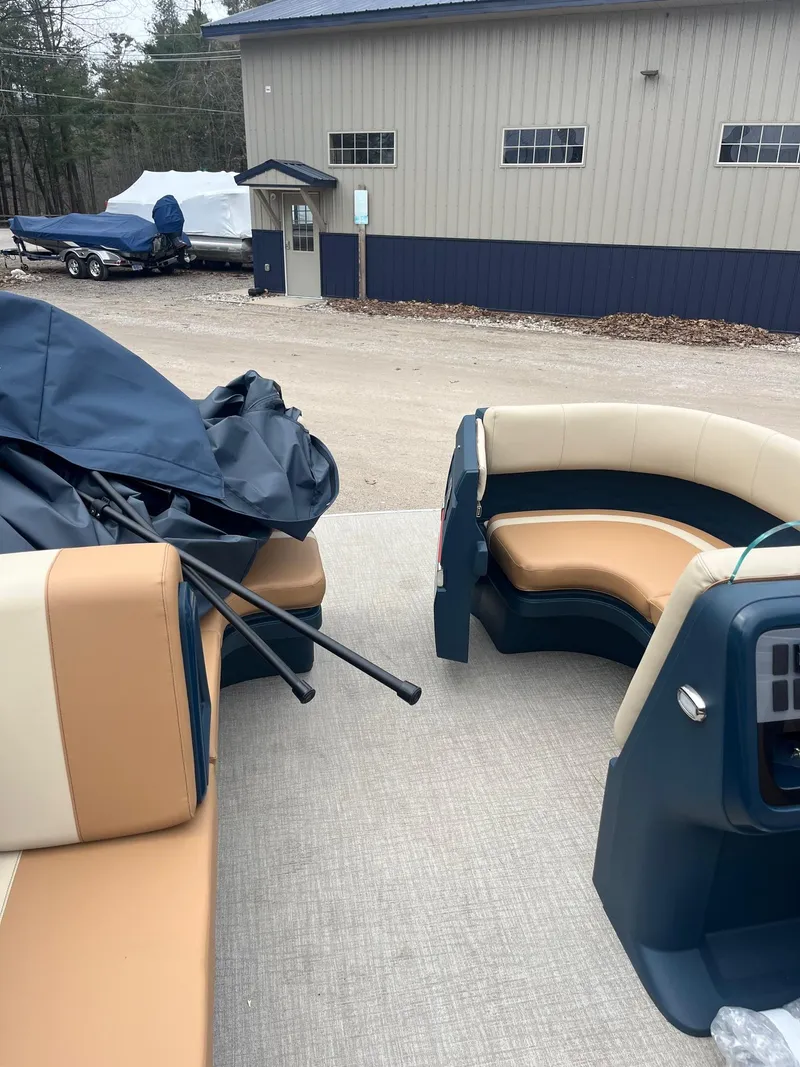 Slide: The Image of Avalon Aura 21 boat interior, 2025 model, with beige and navy seating near a storage facility. - 4