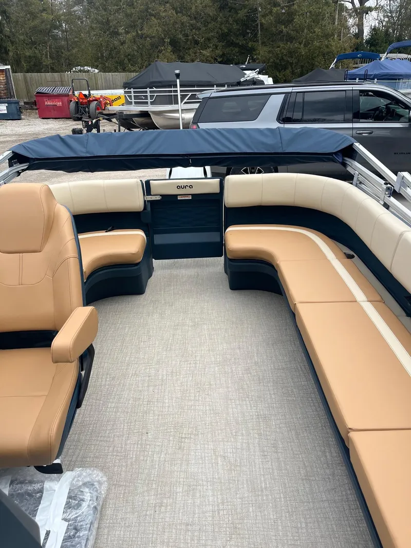 Slide: The Image of 2025 Avalon Aura 21 boat interior with tan seating and blue accents. - 6