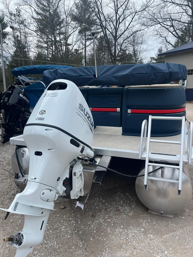 Slide: The Image of 2025 Avalon Aura 21 pontoon boat with Suzuki outboard motor, parked outdoors. - 7