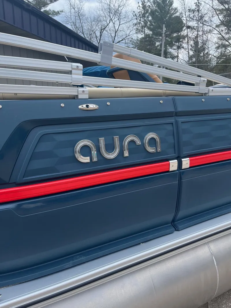 Slide: The Image of 2025 Avalon Aura 21 boat, blue exterior with red trim, docked outdoors. - 8