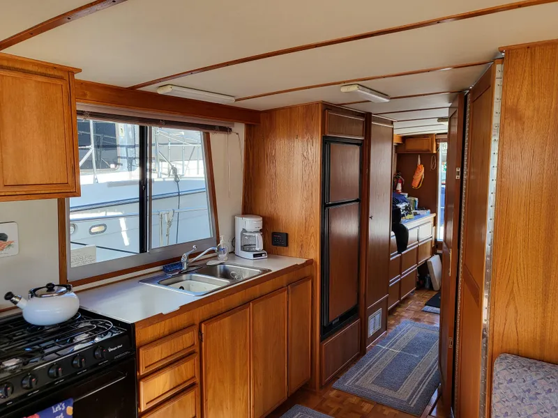 Slide: The Image of Interior of a 1992 Corsair 42 boat with wooden cabinetry and kitchen amenities. - 11