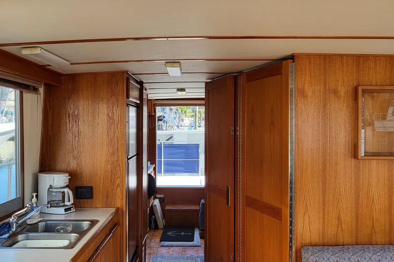 Slide: The Image of Interior of 1992 Corsair 42 boat with wooden paneling and kitchenette. - 13