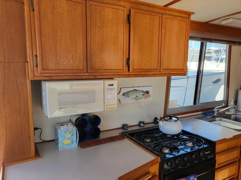 Slide: The Image of Kitchen area of a 1992 Corsair 42 boat with wooden cabinets and appliances. - 14